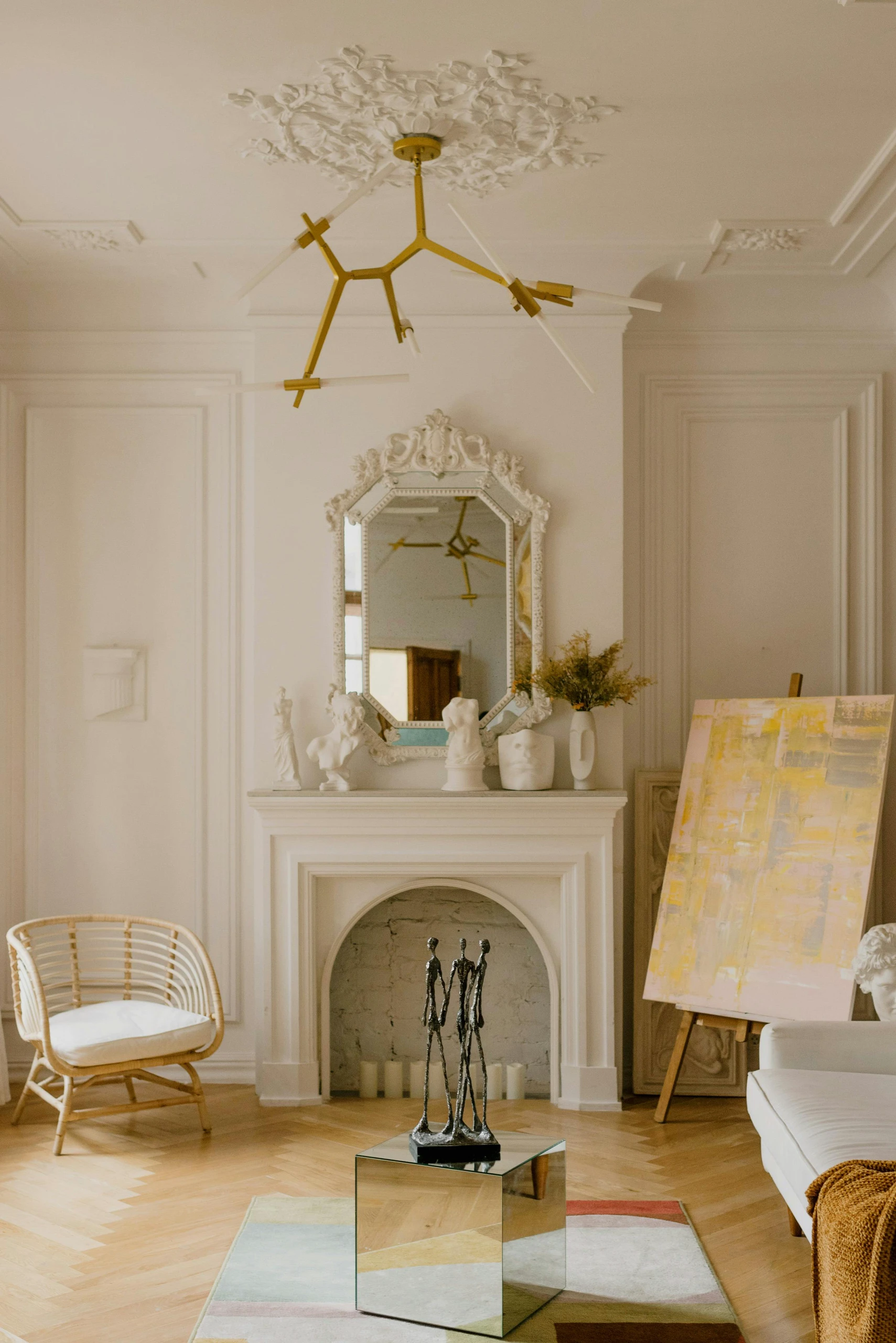 Elegant living room featuring intricate decorative wall molding, a classic fireplace with sculptures, and a large mirror, showcasing timeless living room decor ideas for walls.