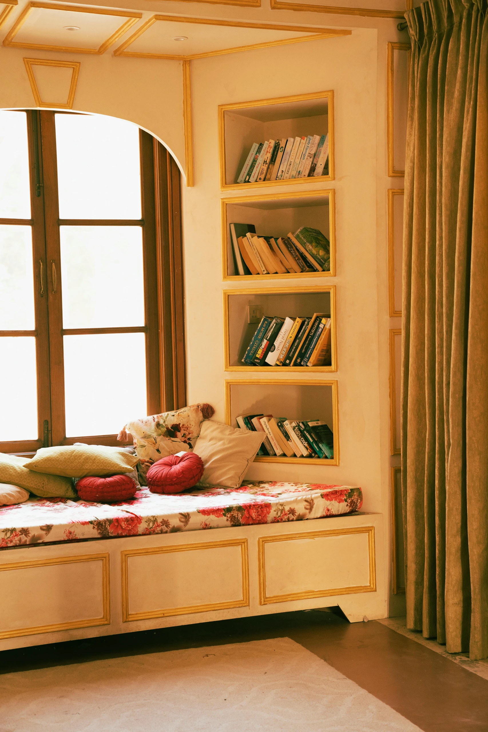 Cozy nook featuring a floral window seat with storage drawers underneath and built-in bookcases, illustrating charming small bedroom ideas with storage like a multifunctional window seat with storage.