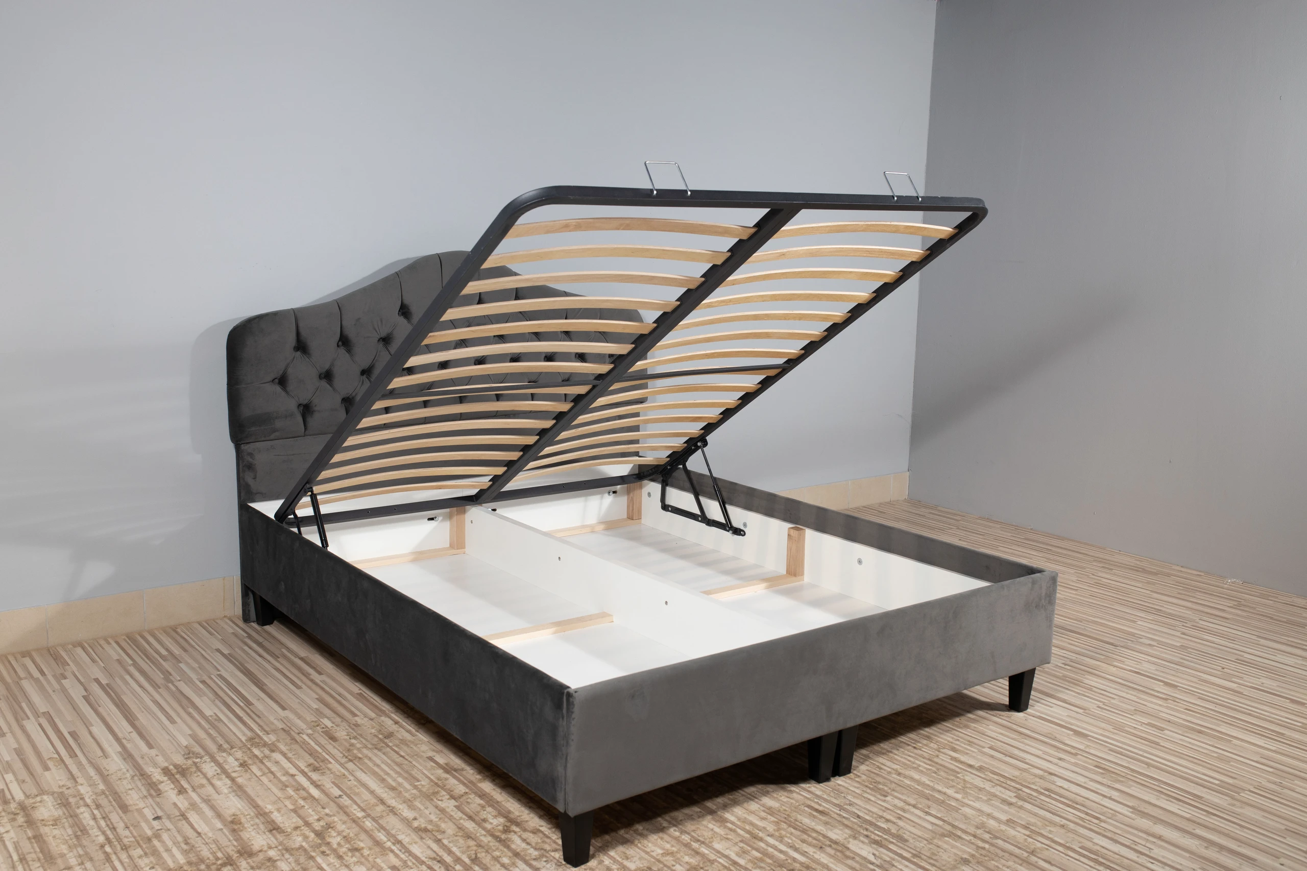 A modern and practical example of small bedroom ideas with storage, this image showcases a folding bed with storage. The upholstered bed lifts to reveal a spacious compartment underneath, divided into sections for neatly storing blankets and linens—ideal for maximizing hidden storage in minimalist bedrooms.