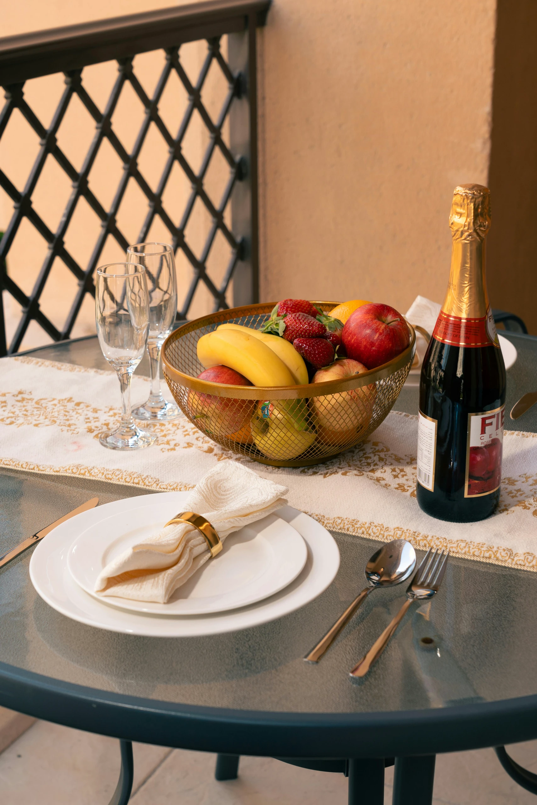 Elegant patio dining setup featuring a glass table with a stylish fruit bowl centerpiece filled with bananas, apples, and strawberries. Perfect for those seeking fresh and vibrant dining table centerpiece ideas.