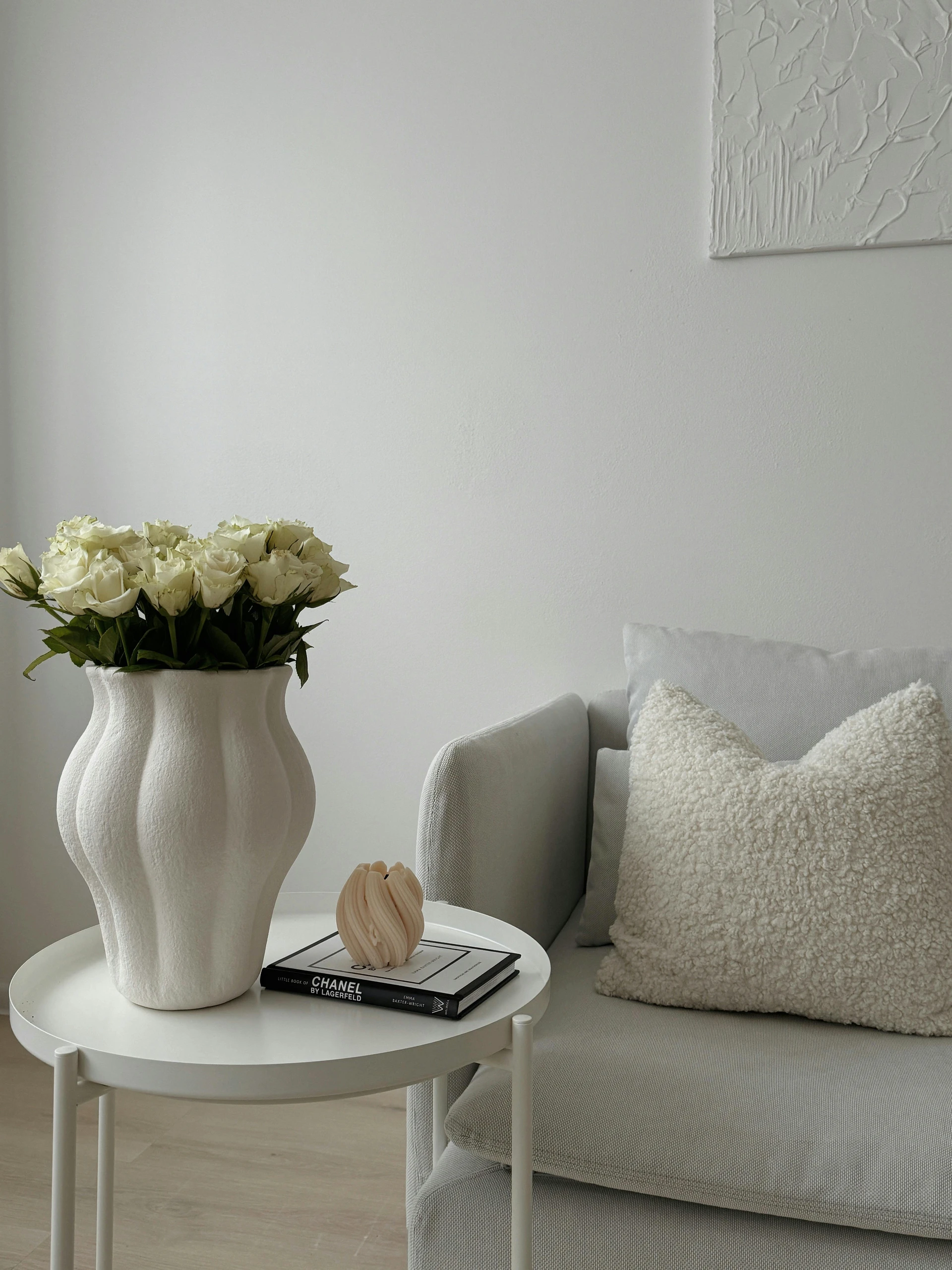 Chic and minimalist setup with a white vase filled with white flowers on a round table, offering timeless dining table centerpiece ideas that suit both casual and elegant settings.