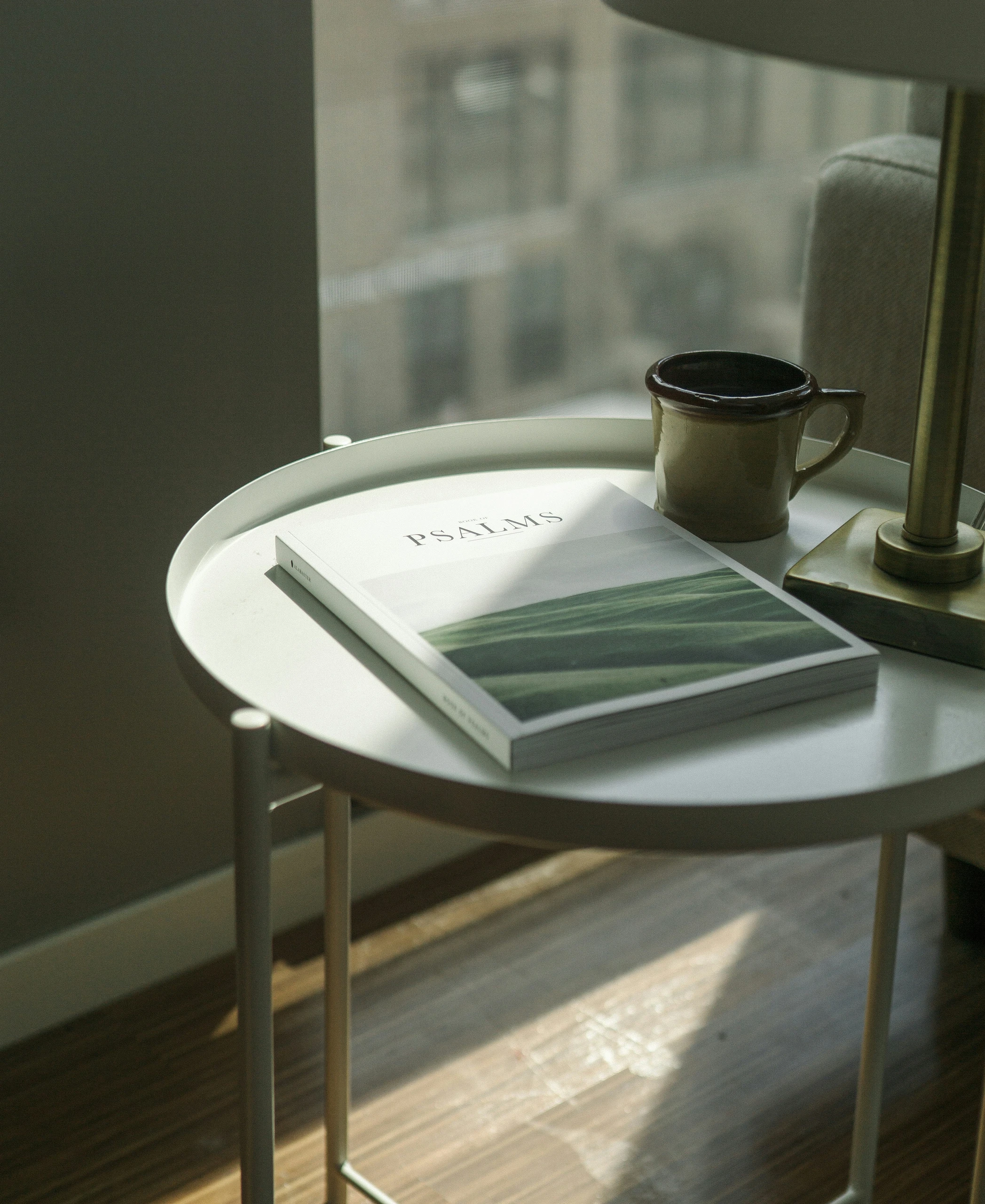 Minimalist inspiration for how to decorate a round coffee table, featuring a single coffee table book titled 