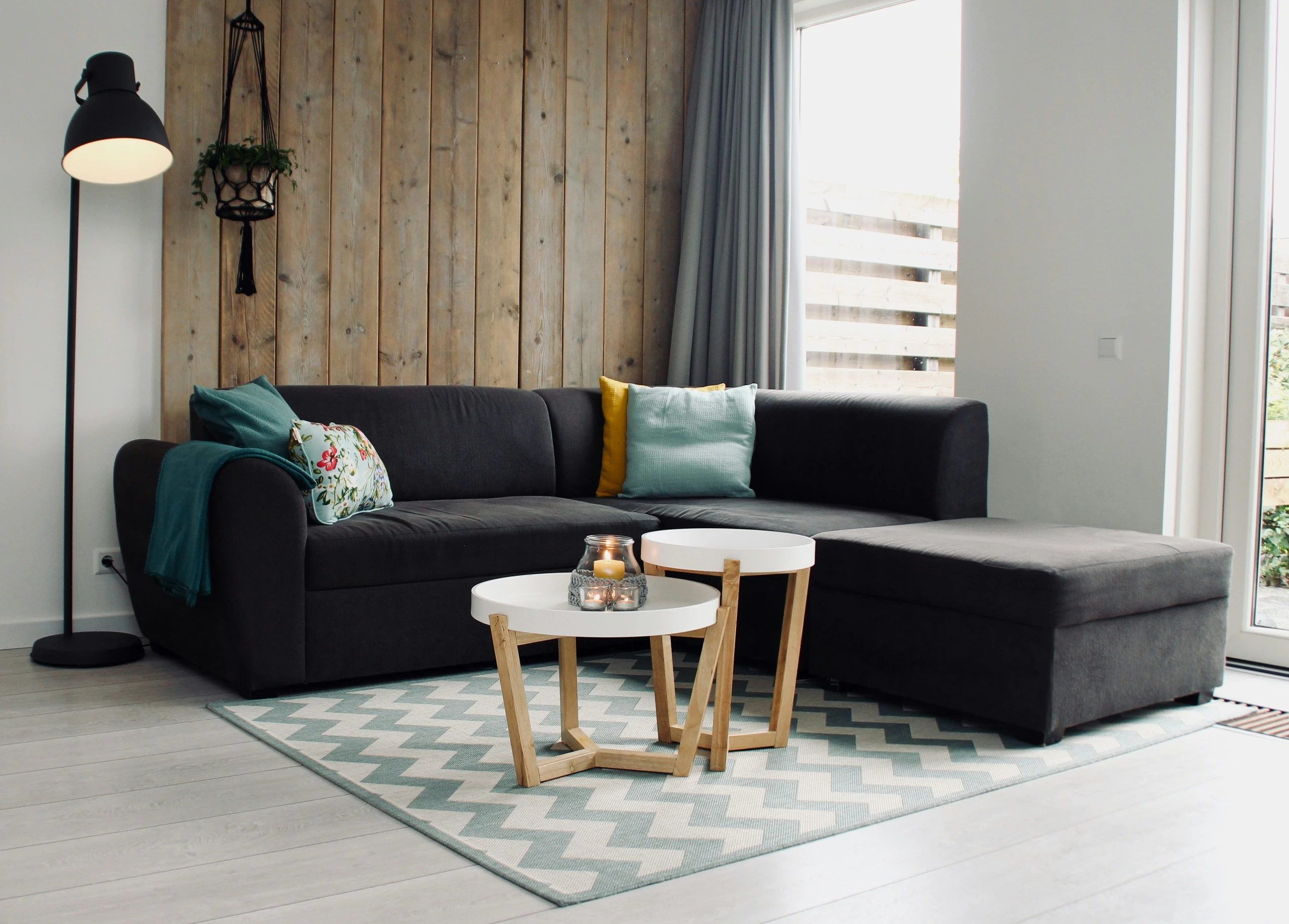 A cozy living room setup showcasing how to decorate a round coffee table with small candles for a warm and inviting touch. The minimalist two-piece coffee table design with white tops and wooden legs offers a versatile base for soft lighting accents, making it suitable for both modern and rustic interiors.