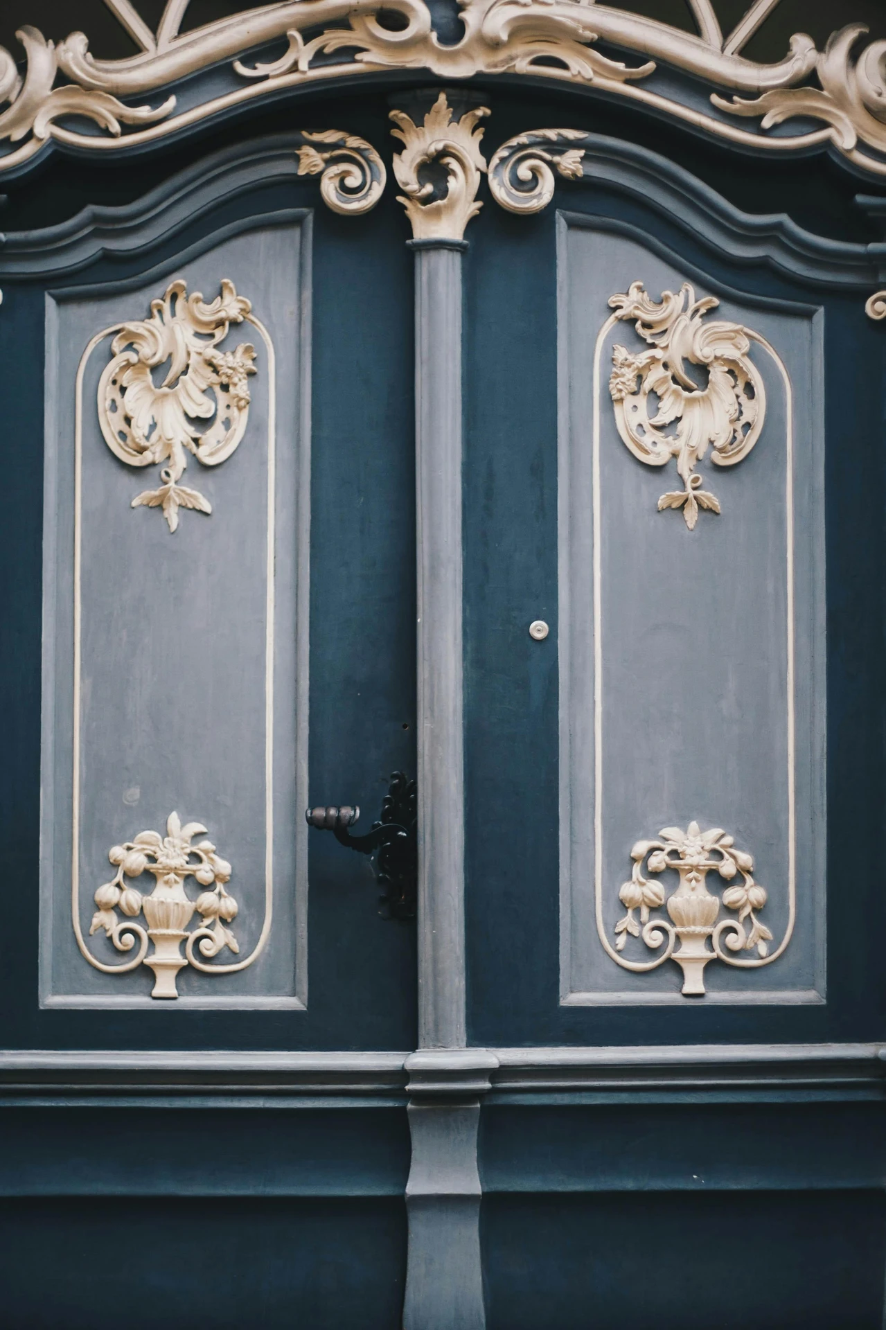 Ornate double front doors painted in deep blue, featuring intricate golden embellishment with floral and scroll motifs. Great inspiration for those exploring ideas for front door decor that showcase luxury and old-world charm.