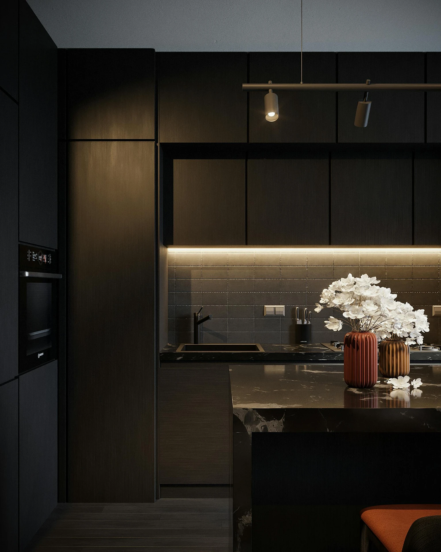 Sophisticated modern kitchen with dark cabinetry and sleek finishes, showcasing a dramatic black marble kitchen island adorned with stylish vases and fresh flowers. An elegant example of kitchen island decor ideas. Warm under-cabinet lighting and minimalist fixtures enhance the luxurious, moody atmosphere while the fresh flowers bring a touch of softness and natural contrast to the contemporary design.