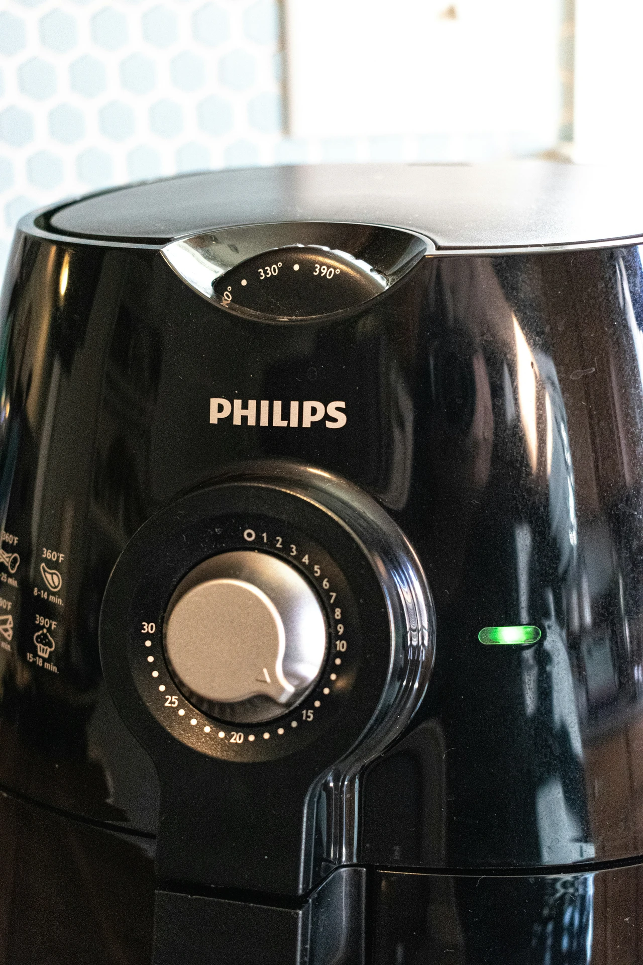 Close-up of a sleek black Philips airfryer, a popular choice among small kitchen appliances for quick and versatile meal preparation. The appliance features adjustable temperature and timer controls, with settings for different foods, making it ideal for frying, baking, and roasting with minimal oil in any modern kitchen.
