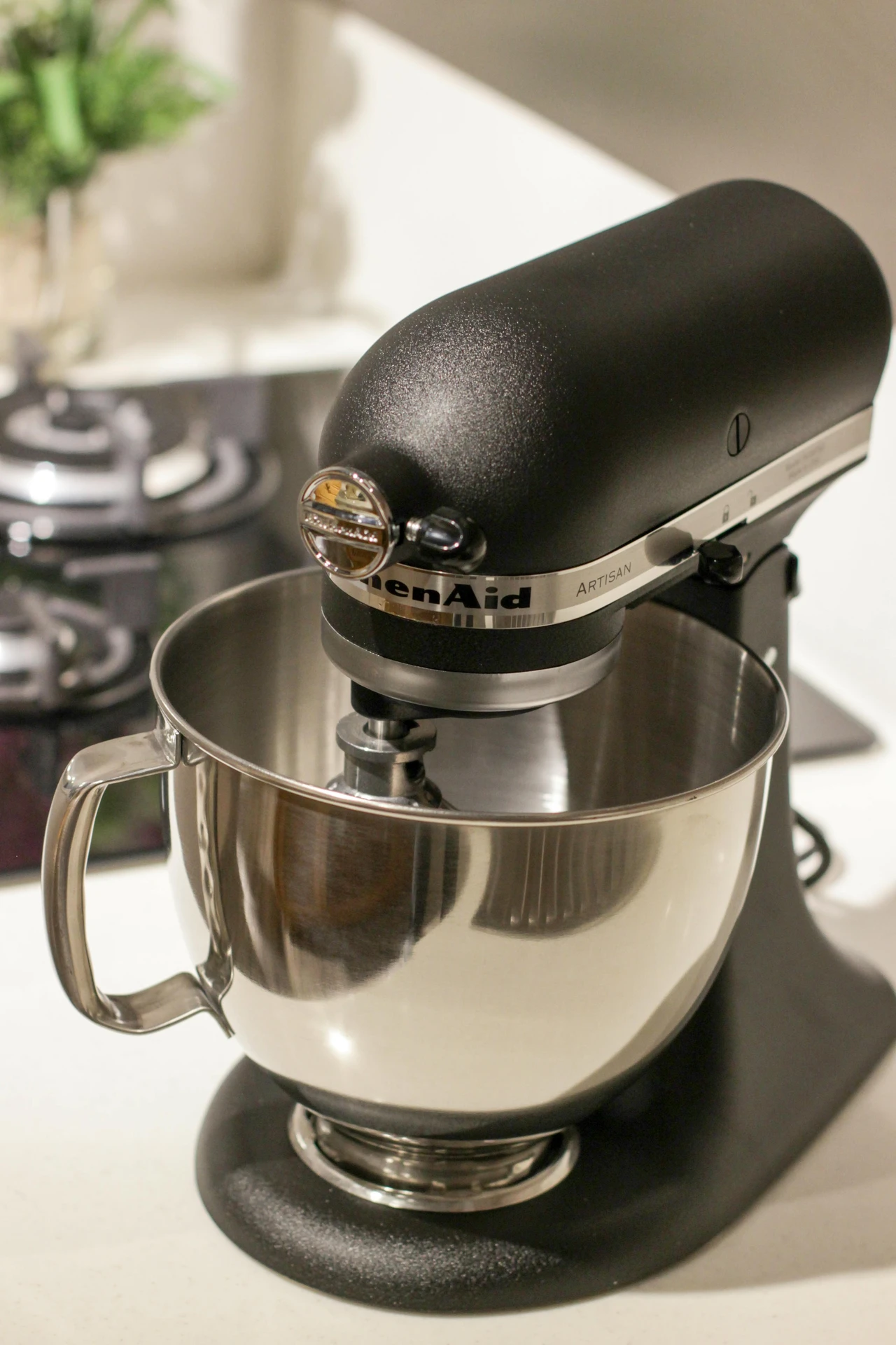 Sleek black stand mixer with a polished stainless steel mixing bowl on a kitchen countertop, showcasing how small kitchen appliances like a stand mixer can handle tasks from whipping cream to kneading bread dough, making both everyday meals and special treats easier to prepare.
