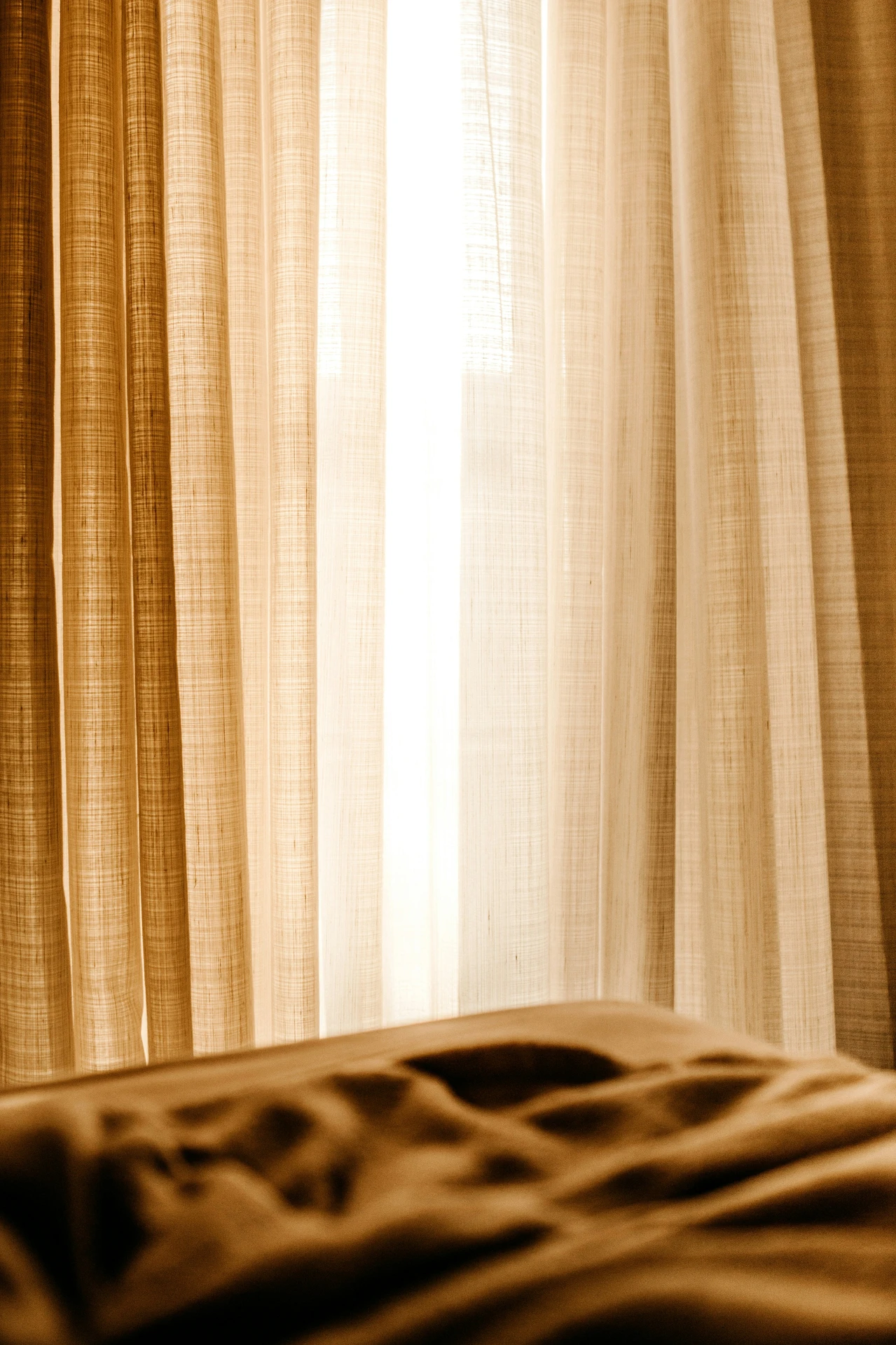Bright and airy curtain ideas for the living room featuring light linen curtains that let natural sunlight gently filter through. The soft beige tones create a warm and cozy atmosphere, adding a versatile and timeless touch that works beautifully in both modern and classic living room designs.