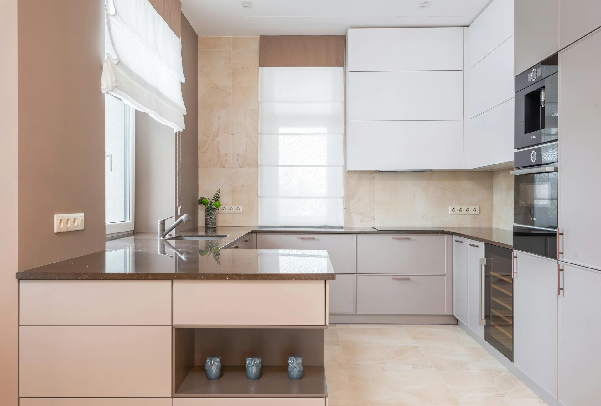 A sleek, modern kitchen with beige cabinets, dark countertops, and built-in appliances, demonstrating how to utilize hidden storage for a clutter-free look. This space-saving setup is a perfect example of kitchen organization ideas for small kitchens, with clean lines, integrated drawers, and minimal open shelving to maximize both function and style.
