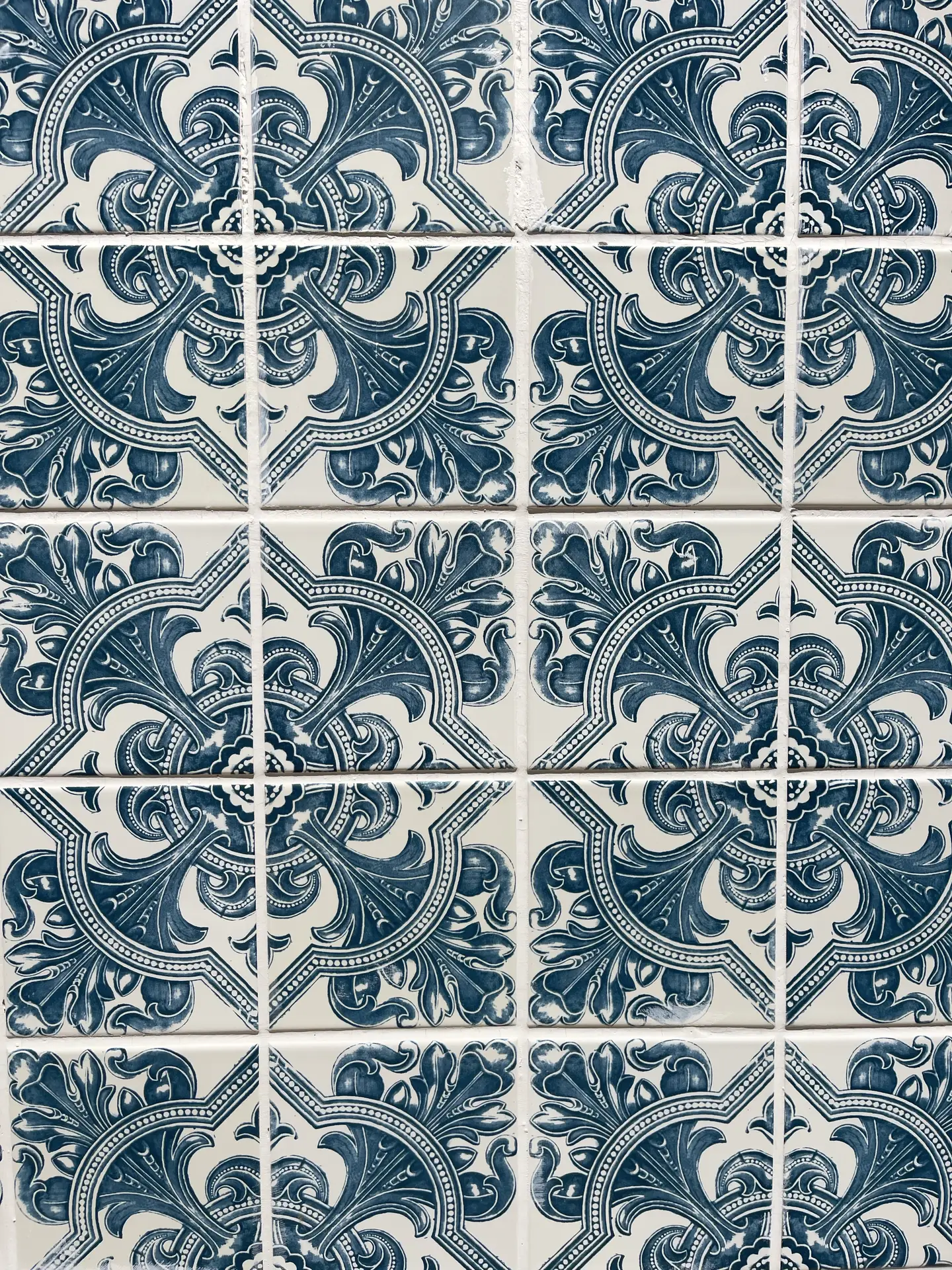A close-up of blue and white Mediterranean patterned tiles featuring ornate floral and geometric motifs. The glossy surface and intricate design bring character and charm to any space, offering inspiring kitchen backsplash ideas for those who love bold, timeless patterns with a coastal or vintage touch.
