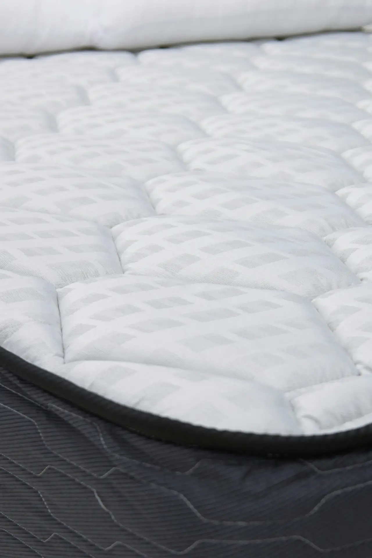 Close-up view of a clean, quilted mattress topper resting on a bed, highlighting texture and freshness as part of a spring cleaning checklist focused on mattress care, airing out bedding, and maintaining a hygienic sleeping space.