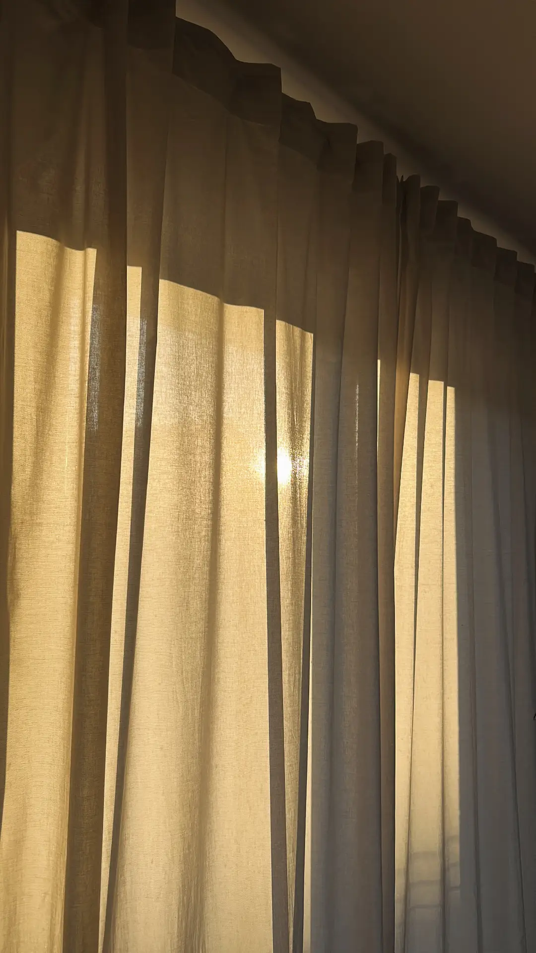 Spring decor ideas for living room showcasing light curtains softly filtering warm sunlight, with sheer fabric panels creating gentle shadows and an airy atmosphere that enhances natural light and a calm, seasonal mood.