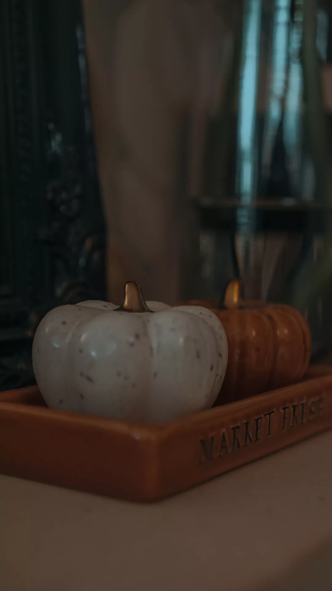 Fall living room decor ideas featuring porcelain pumpkins on a tray, with white and warm orange pumpkins creating a simple, cozy autumn display.