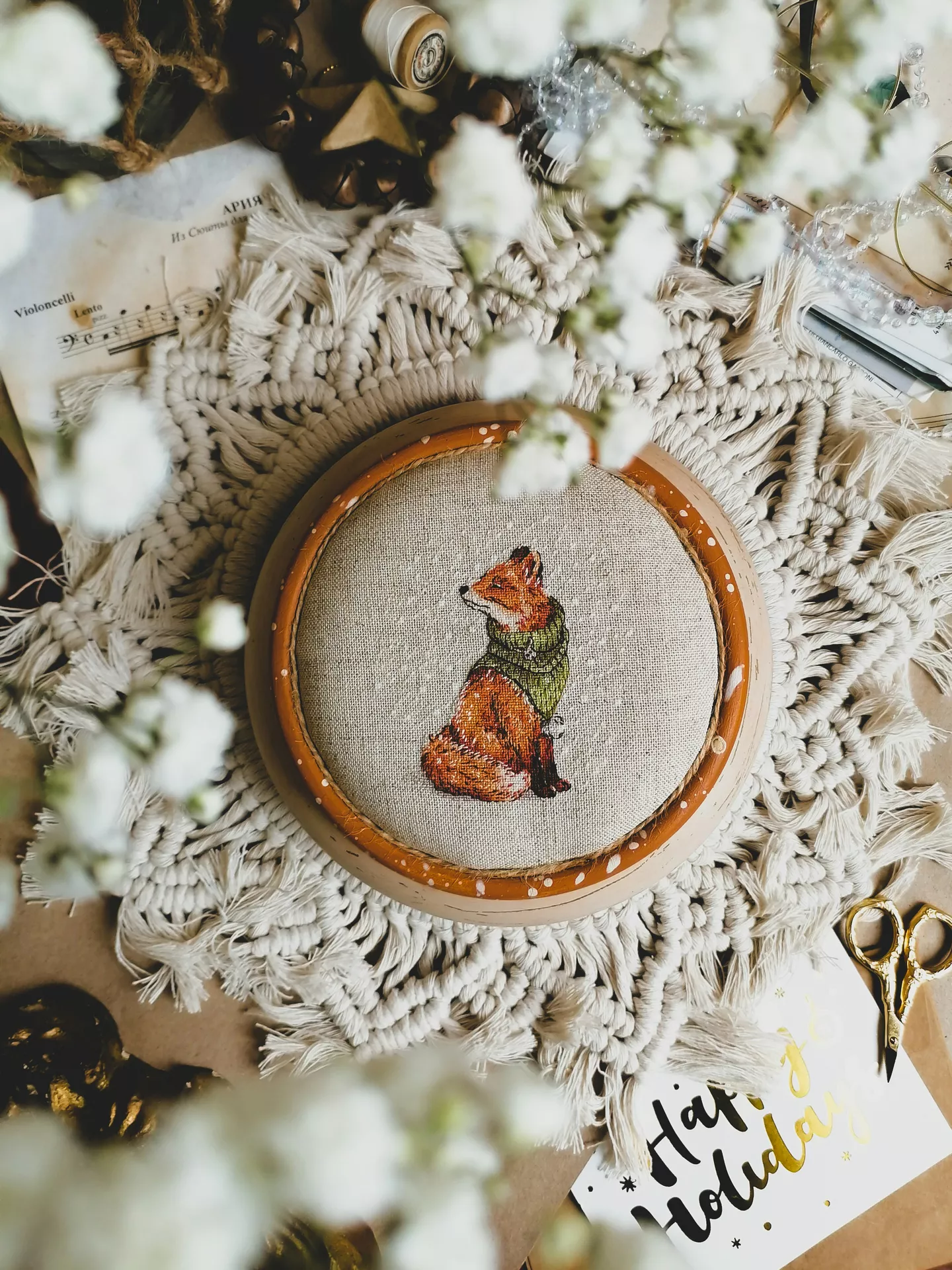 DIY autumn craft ideas featuring cozy embroidery of a fox wearing a green scarf, displayed in a wooden hoop and surrounded by macramé, flowers, sheet music, and vintage crafting supplies.