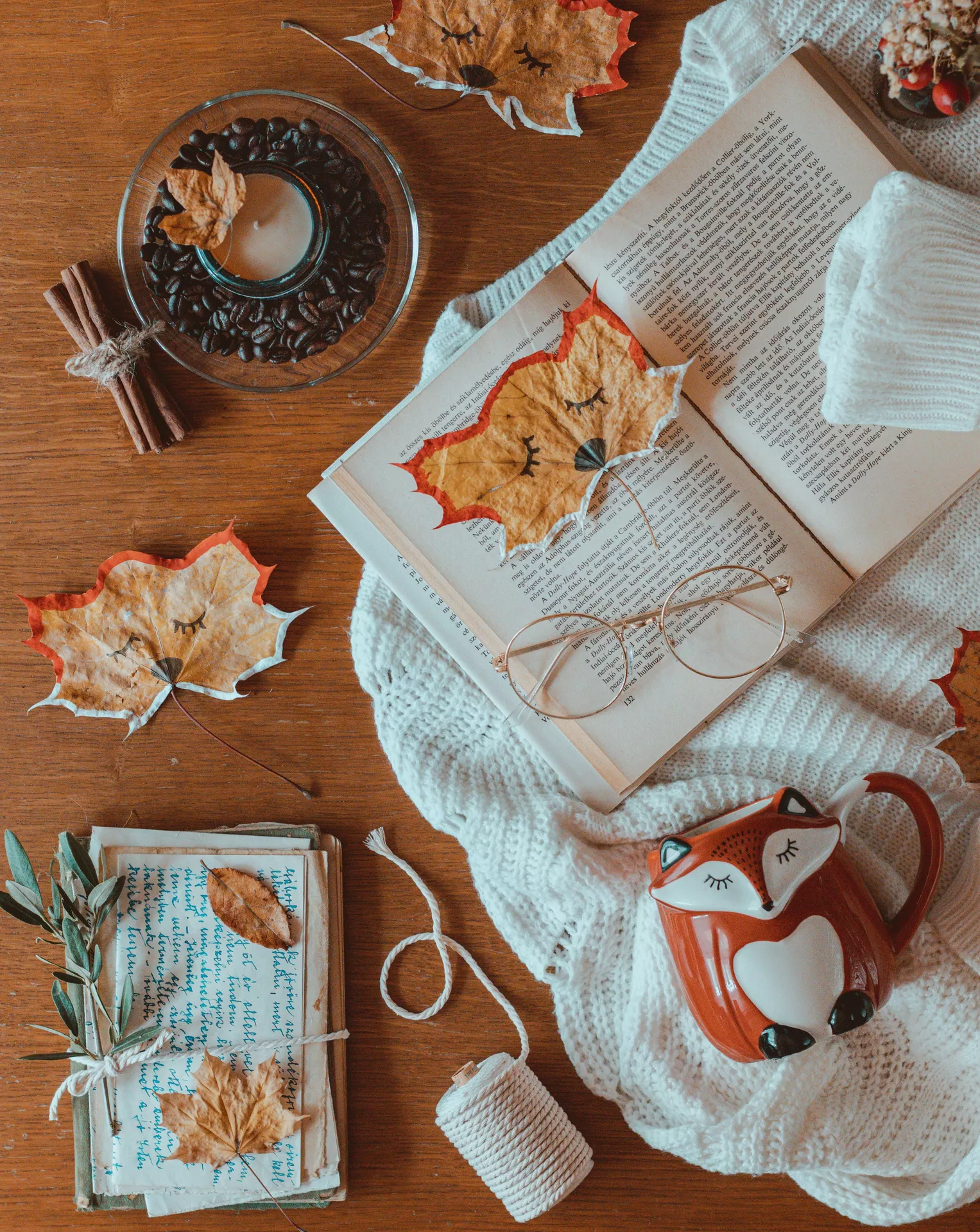 DIY autumn craft ideas featuring Making Forest Animal Crafts Out Of Leaves, with dried maple leaves decorated as cute woodland animals alongside an open book, cozy knit blanket, fox mug, coffee beans, and cinnamon sticks.