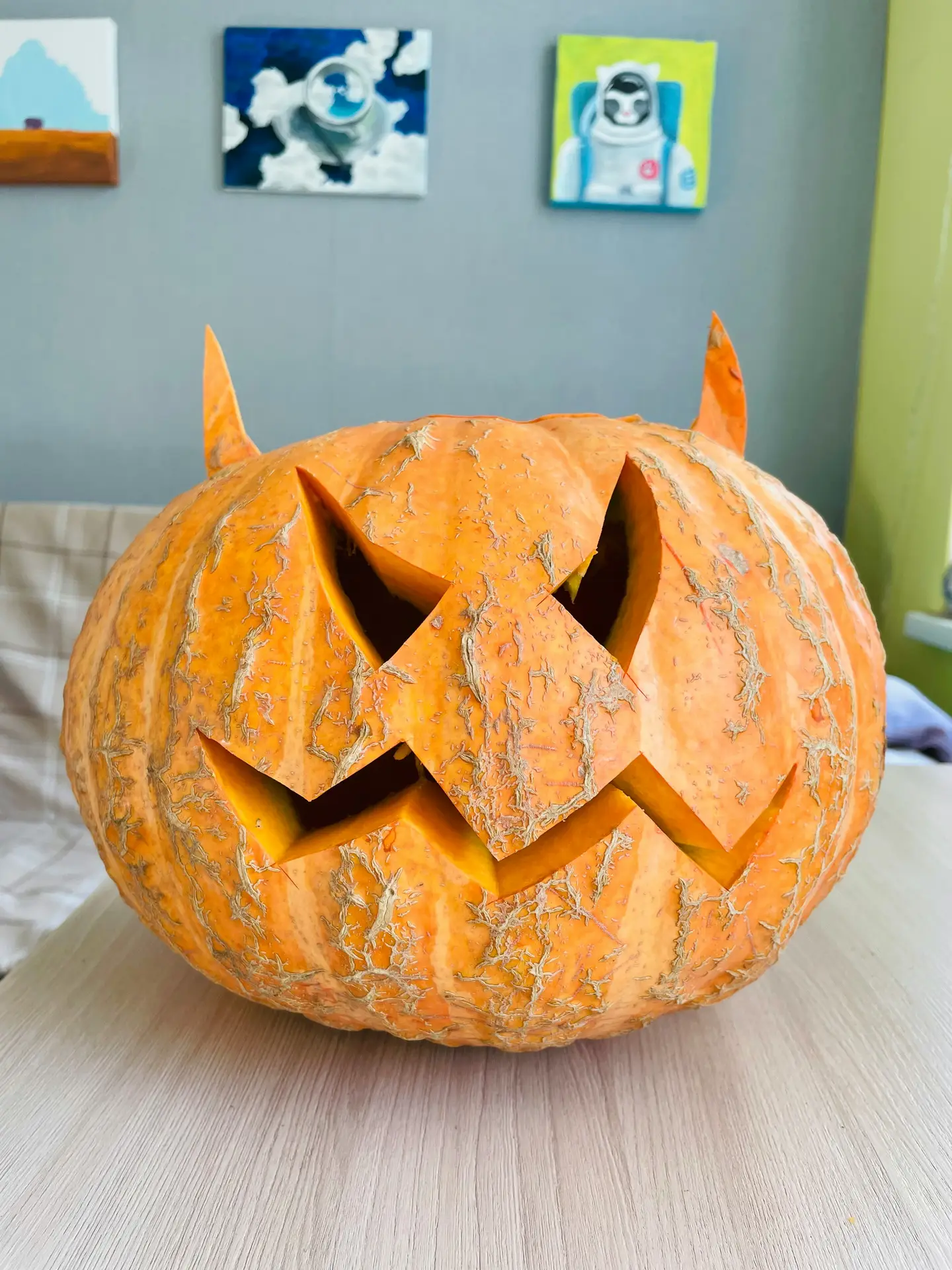 Pumpkin carving ideas featuring a devil pumpkin with pointed horns, sharp triangular eyes, and a jagged sinister mouth for a spooky Halloween decoration.