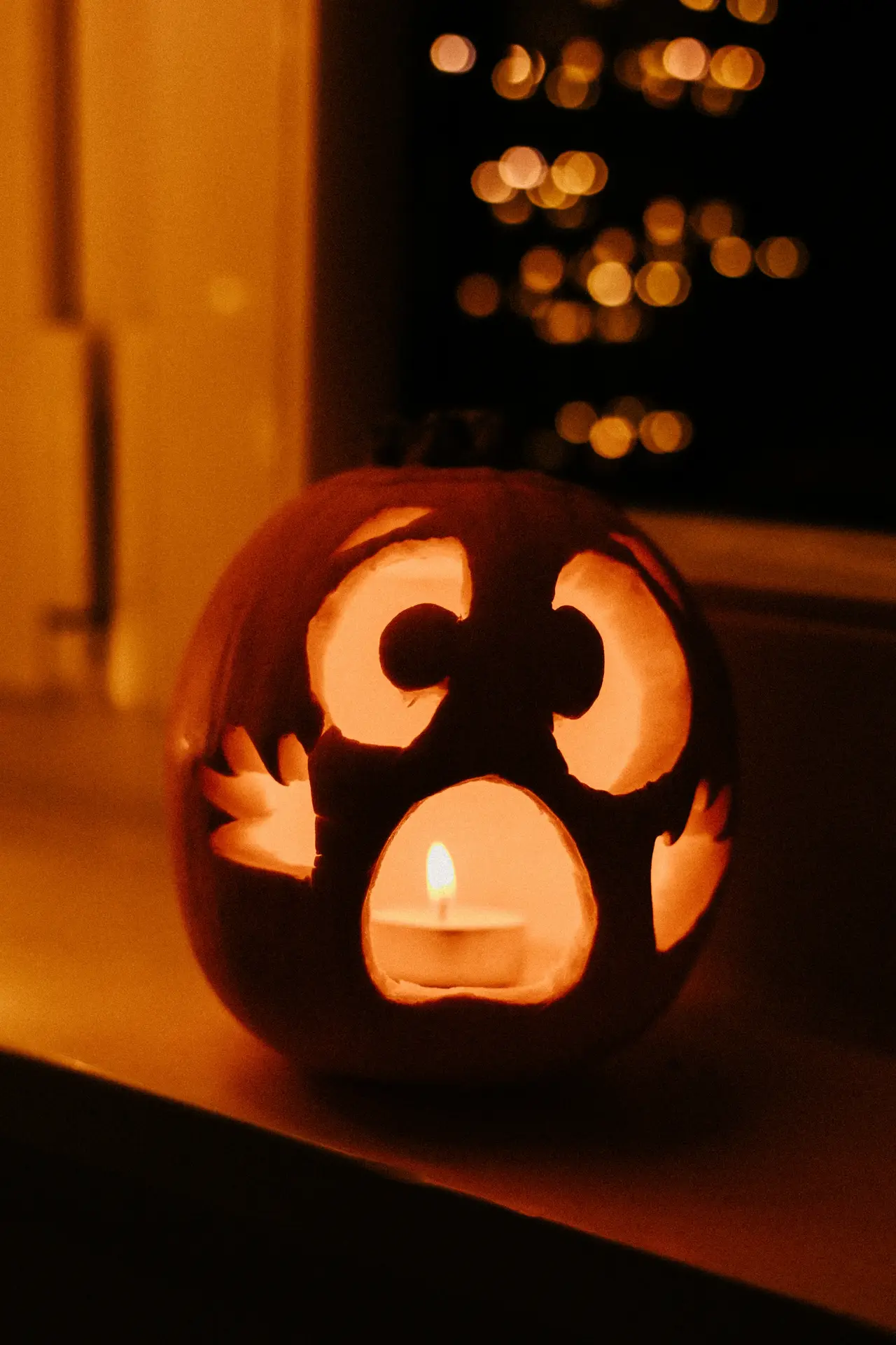 Pumpkin carving ideas featuring a glowing jack-o-lantern with a frightened face, wide eyes, raised brows, and an open mouth illuminated by a tea light.
